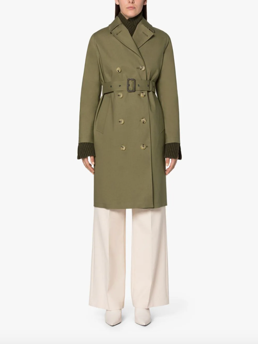 Female model wearing a khaki green colored trench coat, double breasted & belted