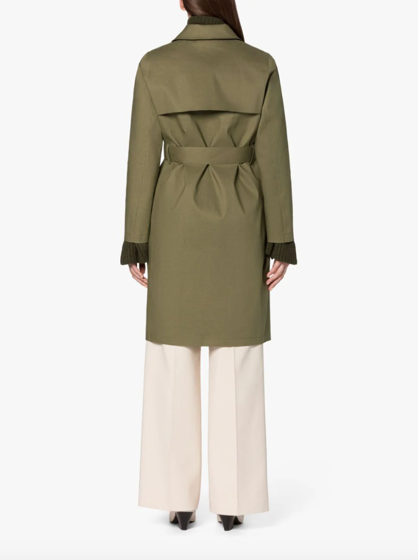 Back view: Female model wearing a khaki green colored trench coat with storm flap and waist belt