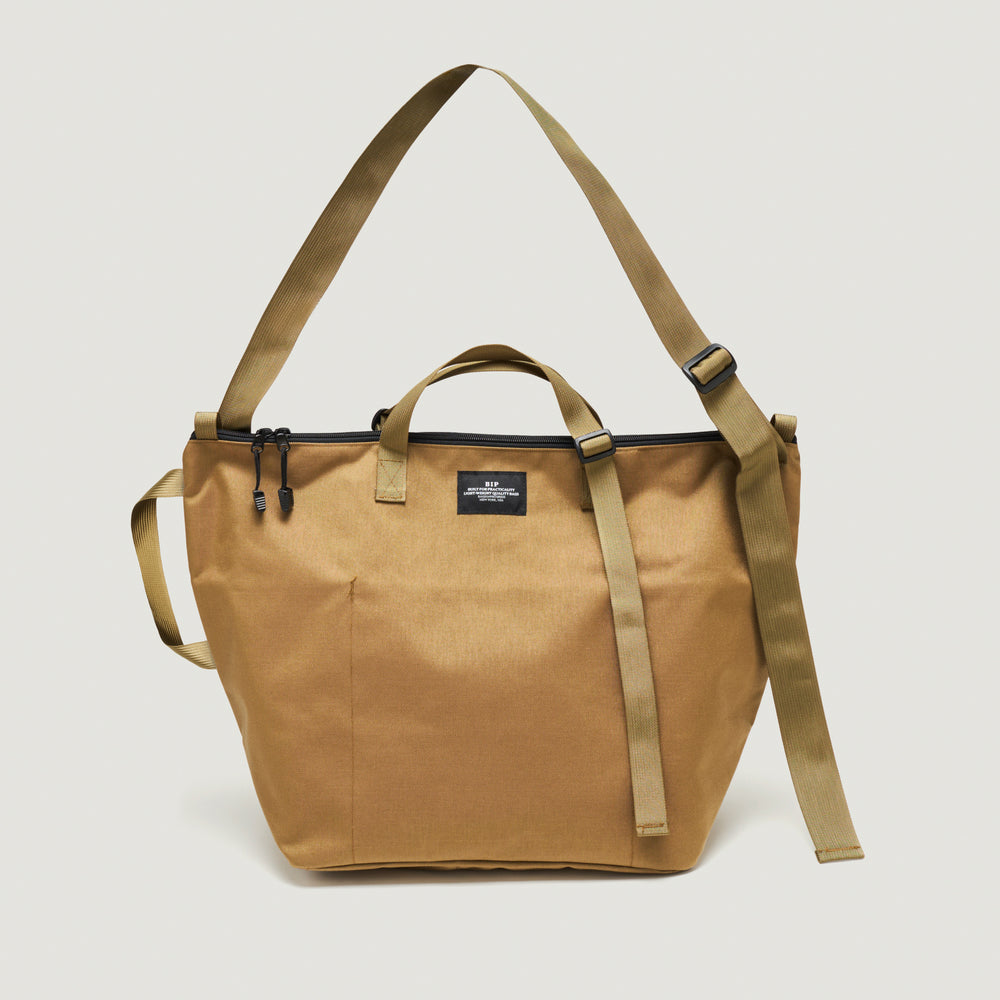Khaki colored canvas tote bag with adjustable nylon webbing handle & shoulder strap, and  zipper closure