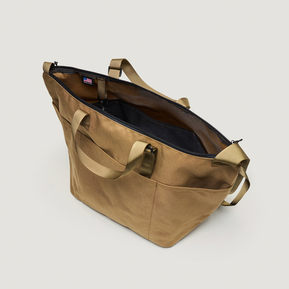 Khaki colored canvas tote bag with exterior pockets, adjustable nylon webbing handle & shoulder strap, and  zipper closure (interior view)