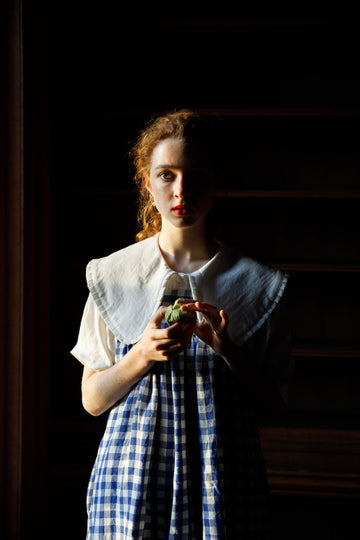 Female model wearing oversize collar white shirt under blue & white gingham dress