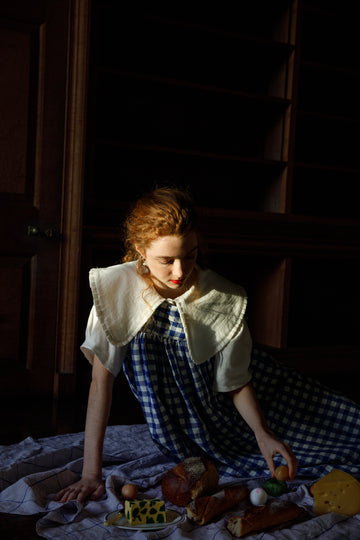Female model wearing oversize collar white shirt under blue & white gingham dress