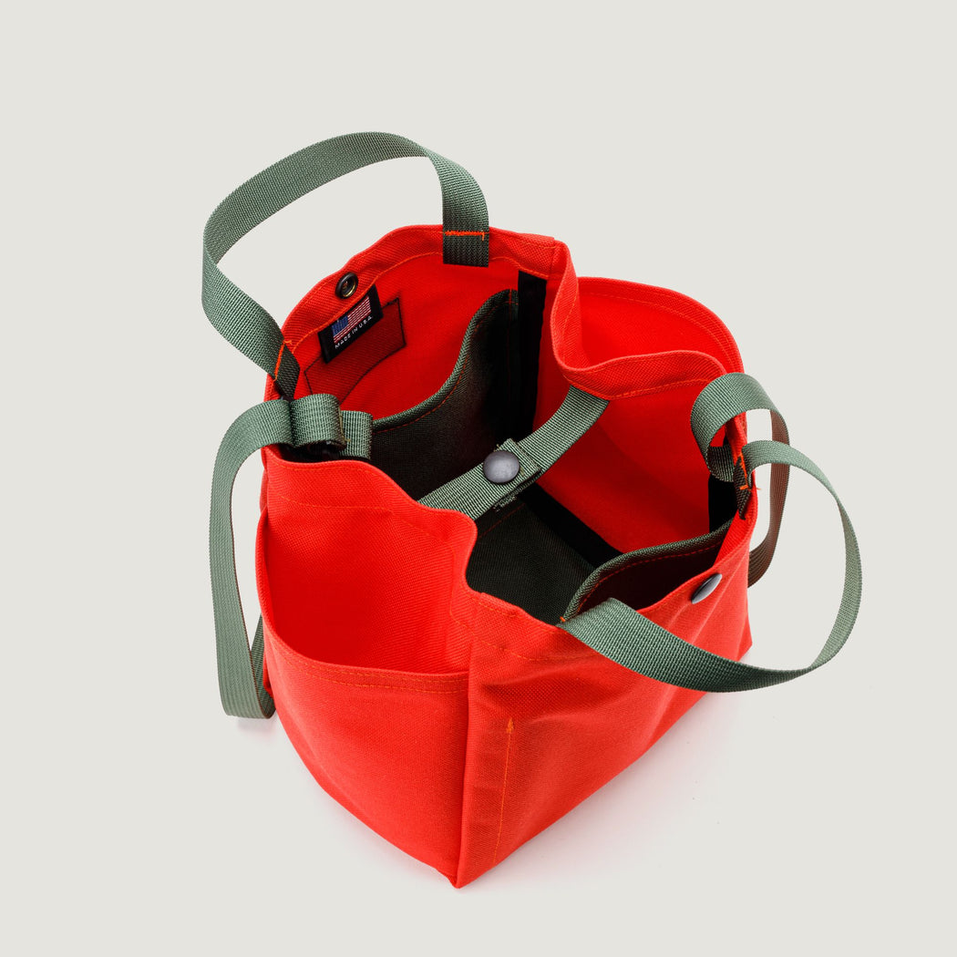 Interior View: Reddish-orange canvas tote with olive green handles & straps + 2 olive green organization pockets & top snap