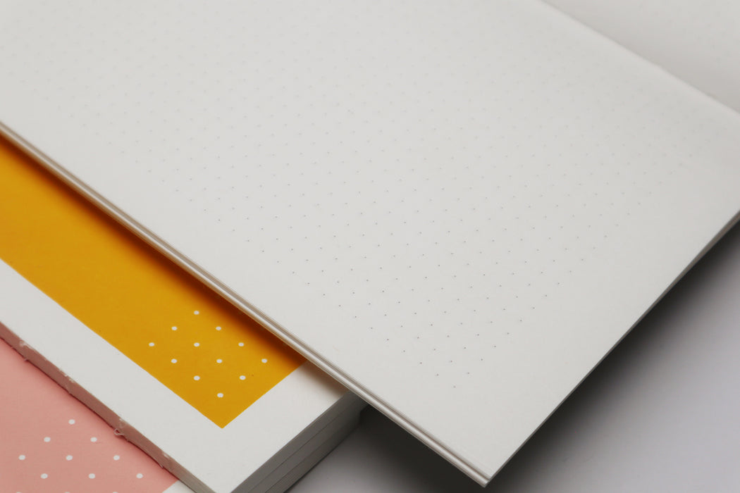 Yellow notebook stacked on top of pink notebook