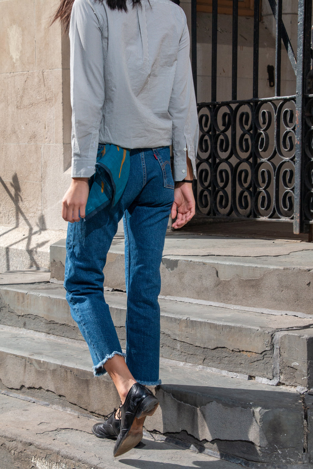 Back view: Model wearing Wedgie Straight Fit Ankle Jeans with blue pocket square coming out of back pocket