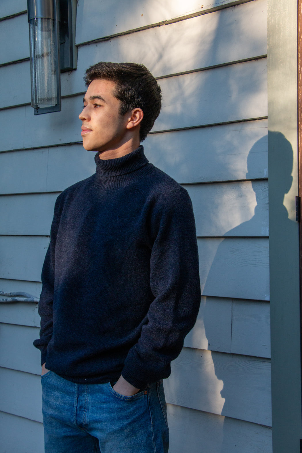 Male model wearing navy long sleeve turtleneck sweater