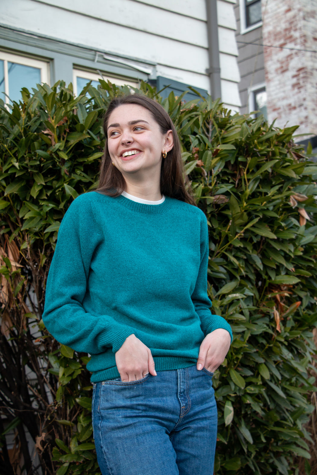 Female model wearing blue long sleeve crew neck sweater with jeans