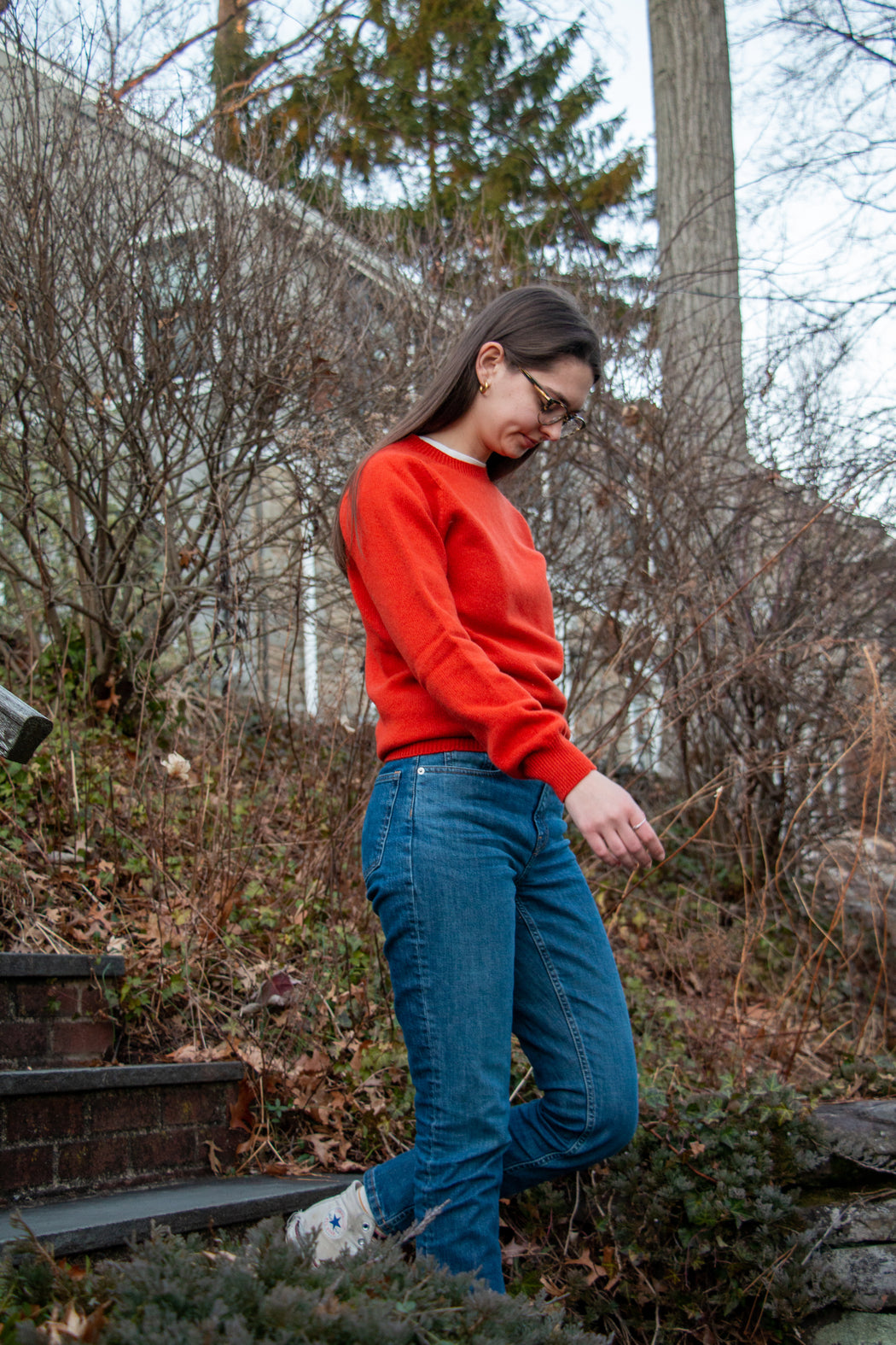 Female model wearing red long sleeve crew neck sweater with jeans