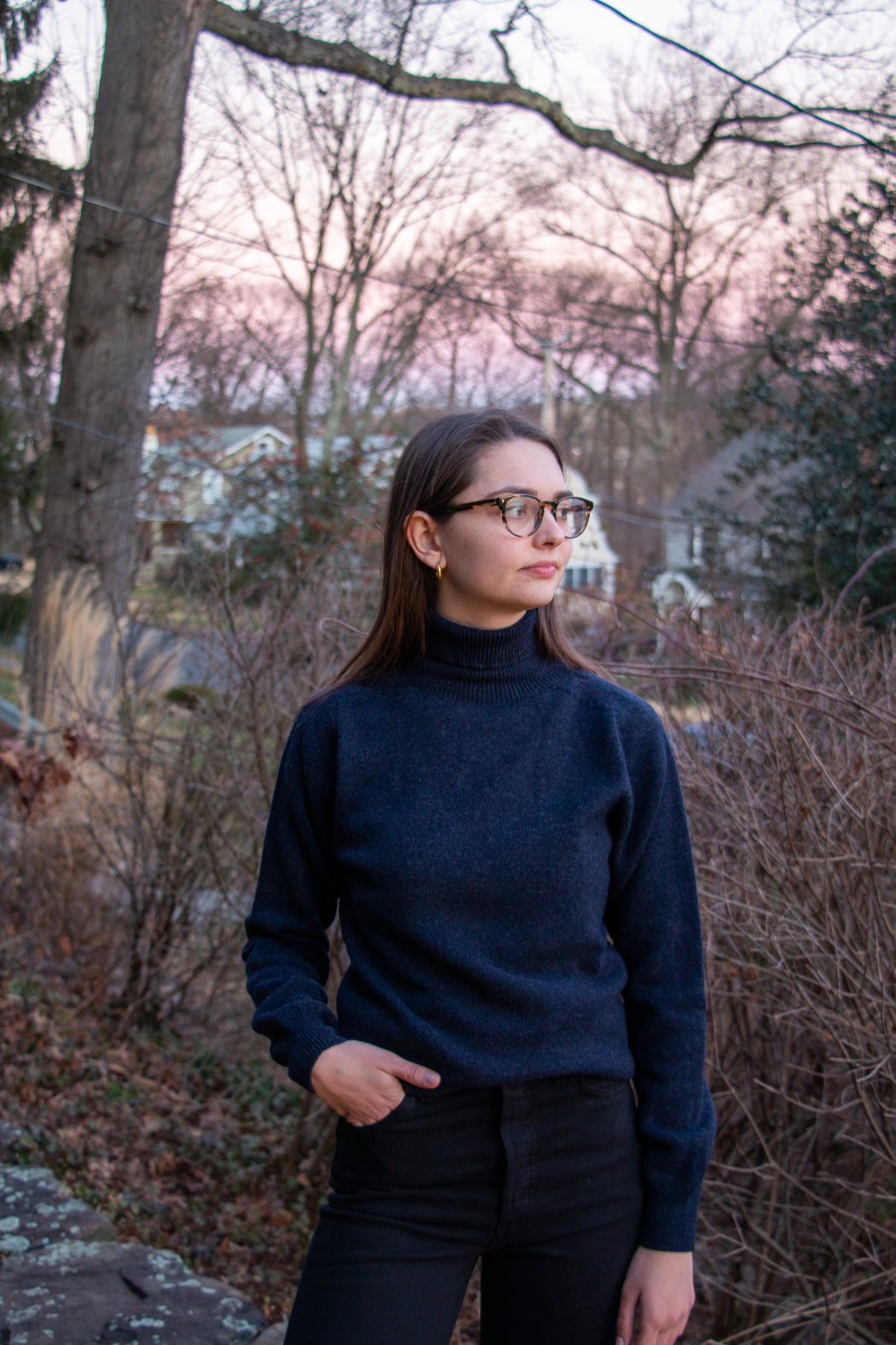 Female model wearing navy long sleeve turtleneck sweater