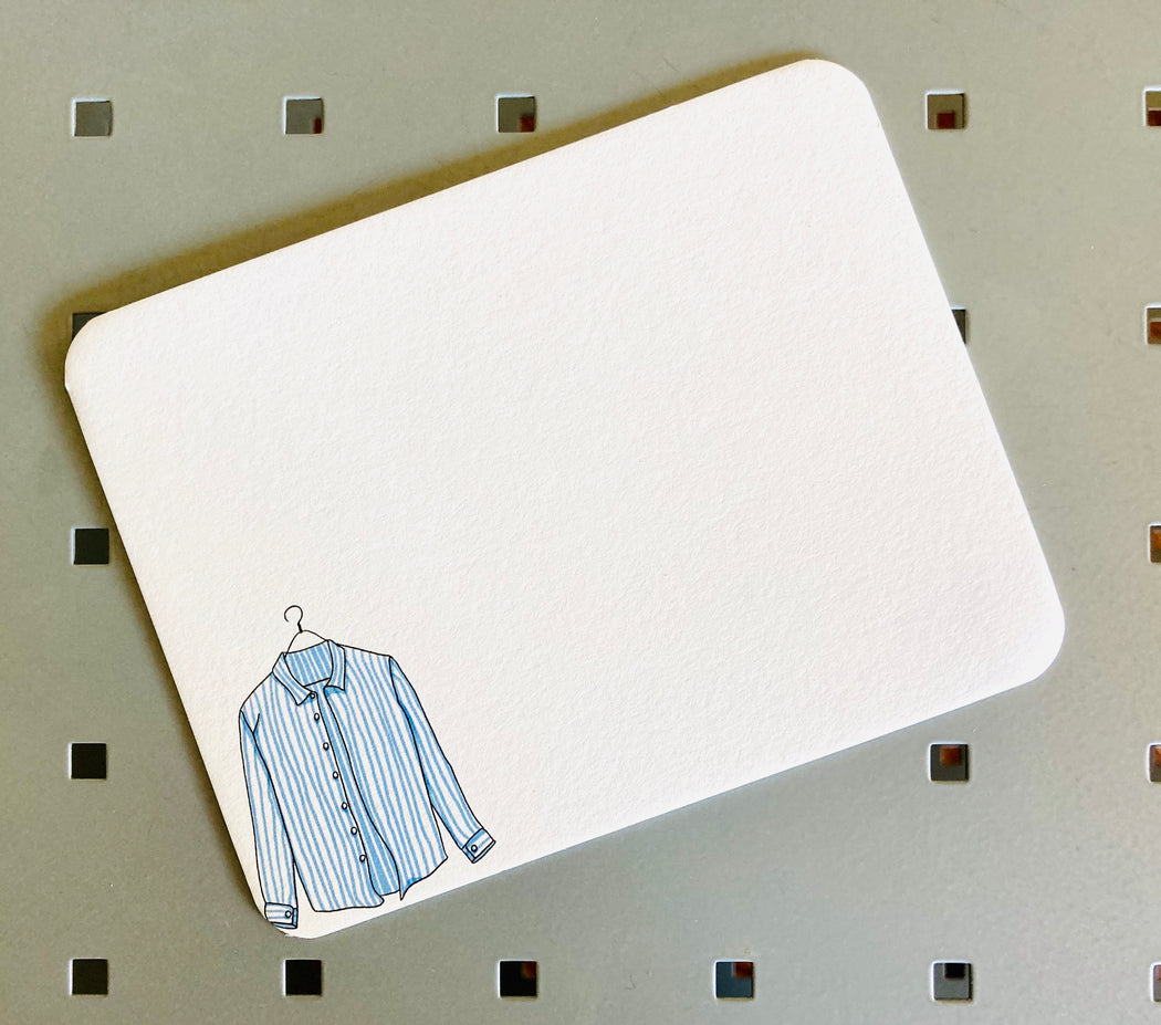 White note card with illustration of a striped shirt on bottom left corner
