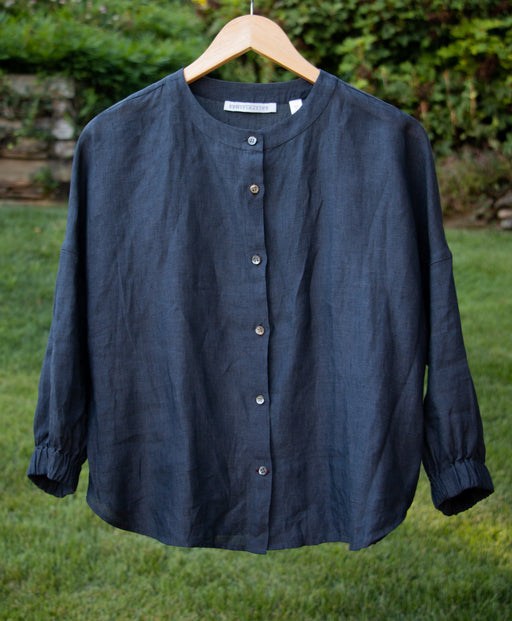 Blue grey long sleeve shirt with button front and rounded neckline, on hanger