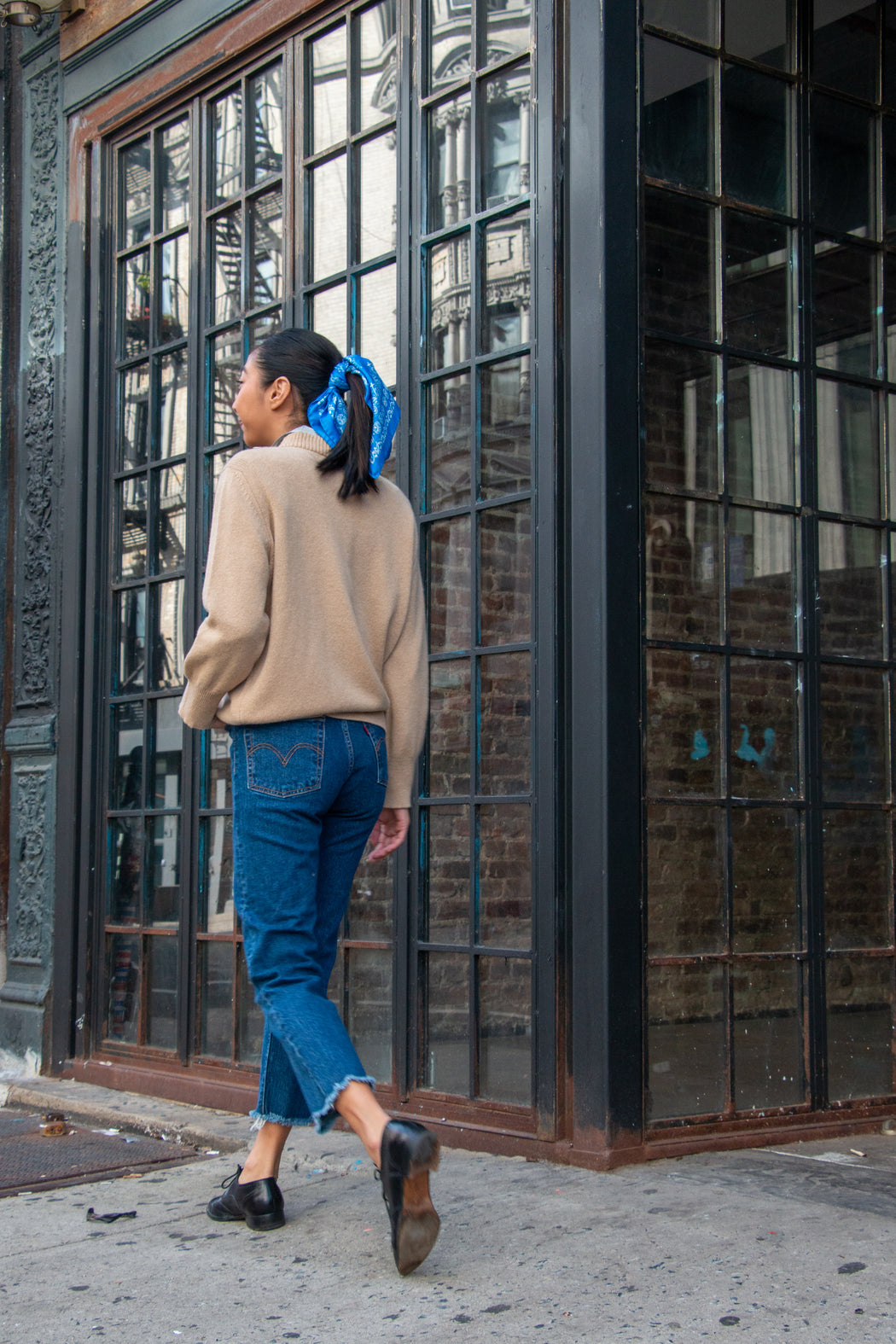 Model wearing tan long sleeve sweater with high neck