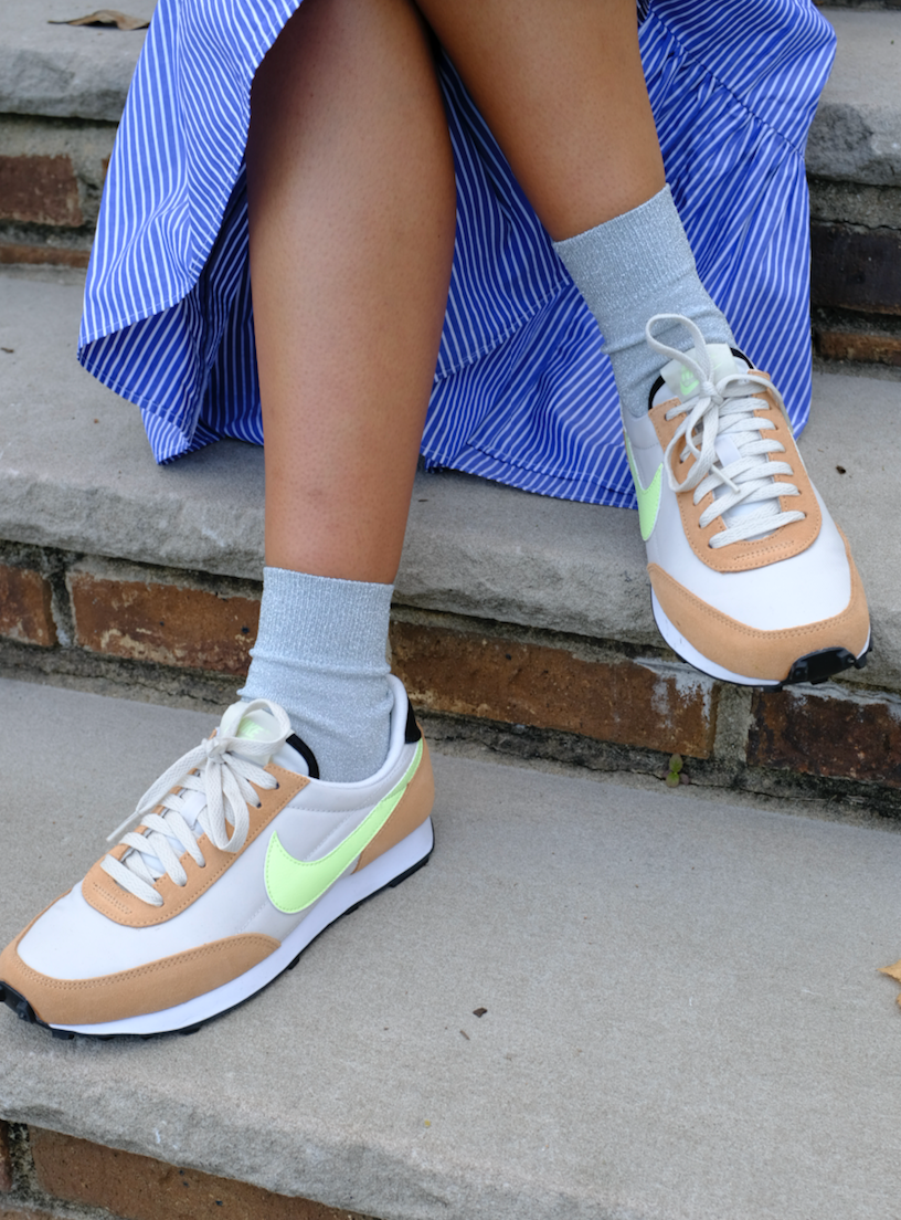 Model wearing grey sparkly socks with sneakers