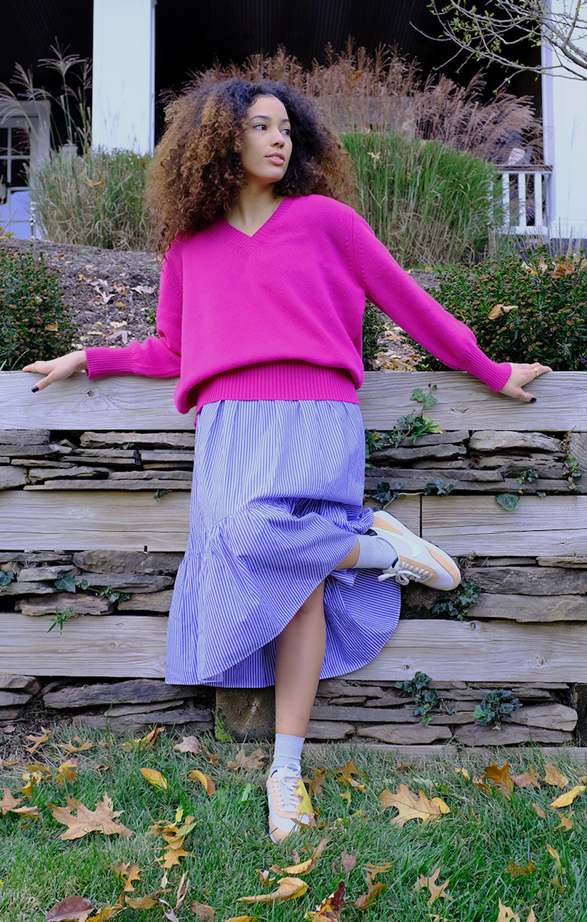 Model wearing hot pink v-neck sweater with skirt