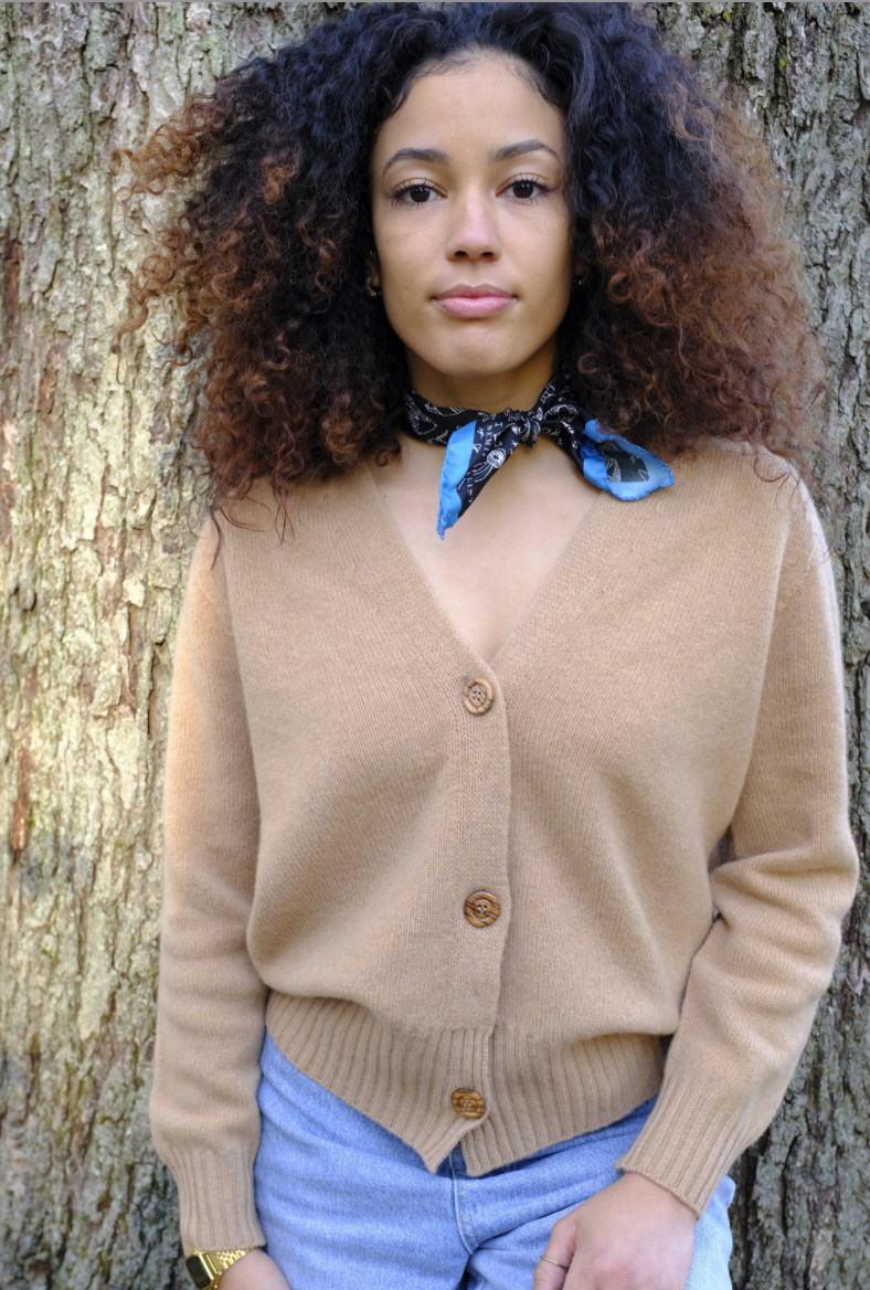 Girl wearing beige long sleeve cardigan sweater with V-neck