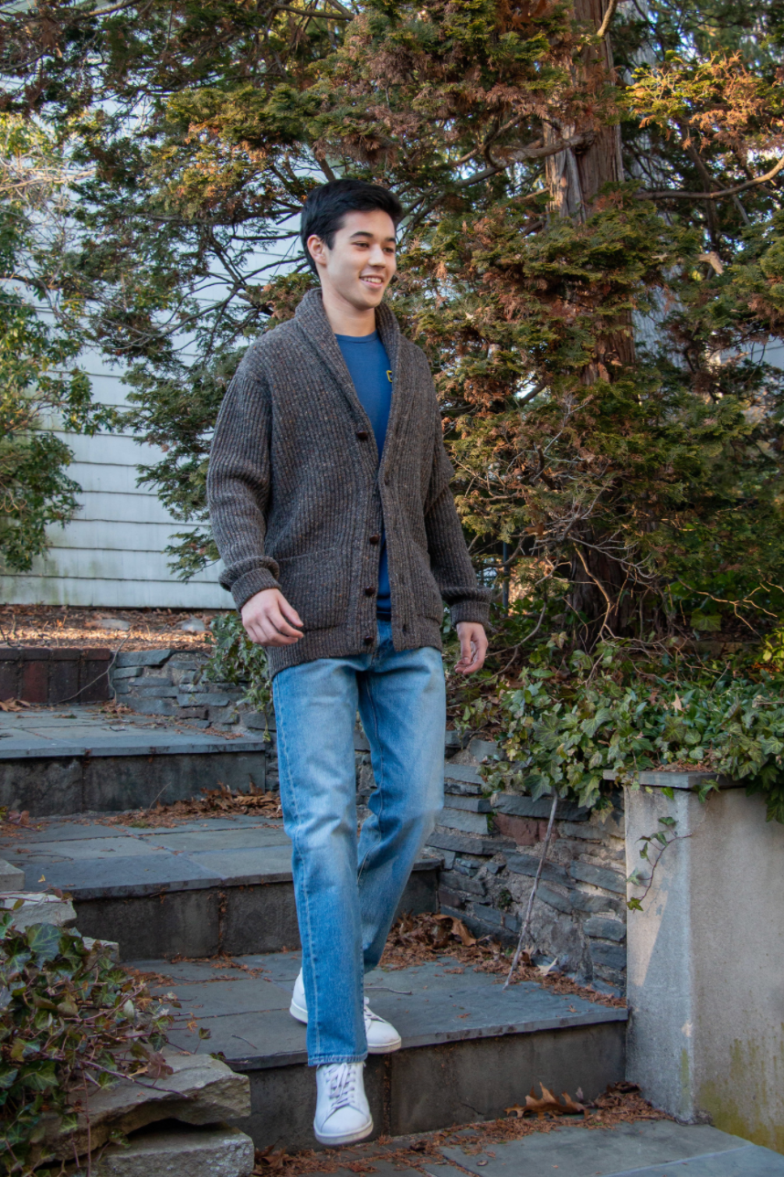 Model wearing brown/grey button-down sweater with 2 front pockets and shawl collar