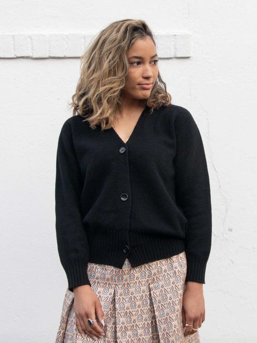 Girl wearing black long sleeve cardigan sweater with V-neck