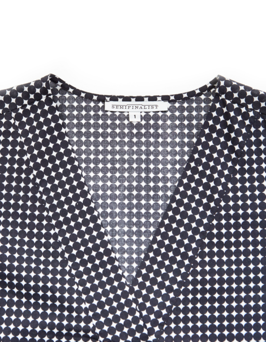 Close-up on V-neck of navy & white polka dot dress