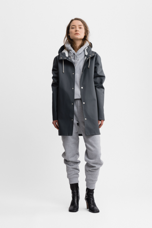 Female model wearing gray long sleeved rain jacket with hood