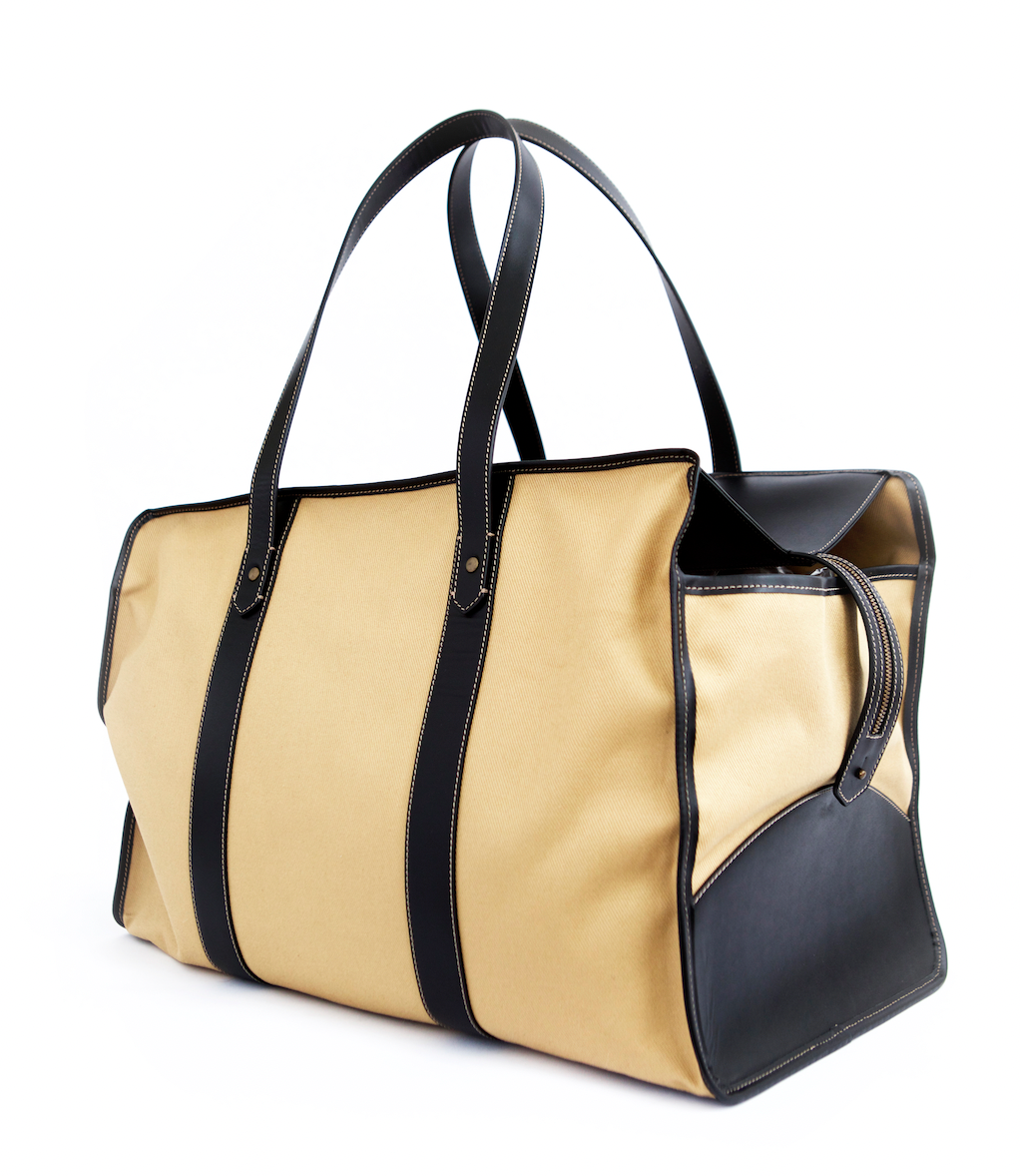 Tan fabric travel bag with black leather straps and trim