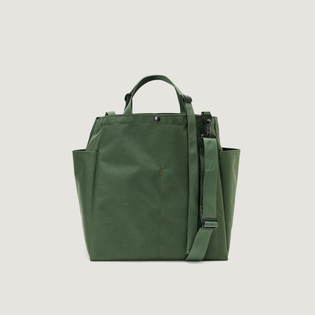 Olive colored tote bag with snap closure, exterior pockets, top handles & shoulder strap (back view)