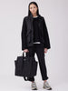Female model holding black canvas tote bag by handles