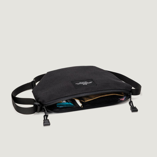 Black small nylon canvas bag with zip closure & adjustable shoulder strap & interior pockets