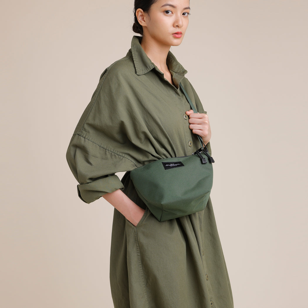Female model wearing Olive green nylon canvas tote in crossbody manner