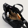 Black canvas tote interior view, featuring 3 large organization pockets in  contrasting tan color
