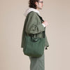 Male model wearing olive green canvas tote with shoulder strap
