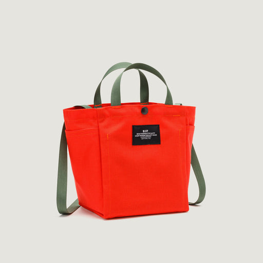 Reddish-orange canvas tote with snap closure, olive green handles & straps