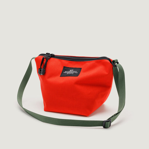 Small reddish-orange nylon canvas bag with zip closure & olive green adjustable shoulder strap