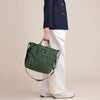 Model holding olive green canvas tote by top handles