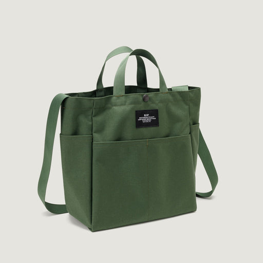 Olive green colored canvas tote with 4 exterior pockets, snap closure, handles & shoulder strap