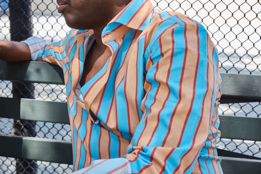 male model wearing turquoise & salmon colored striped long sleeve button down men's shirt 