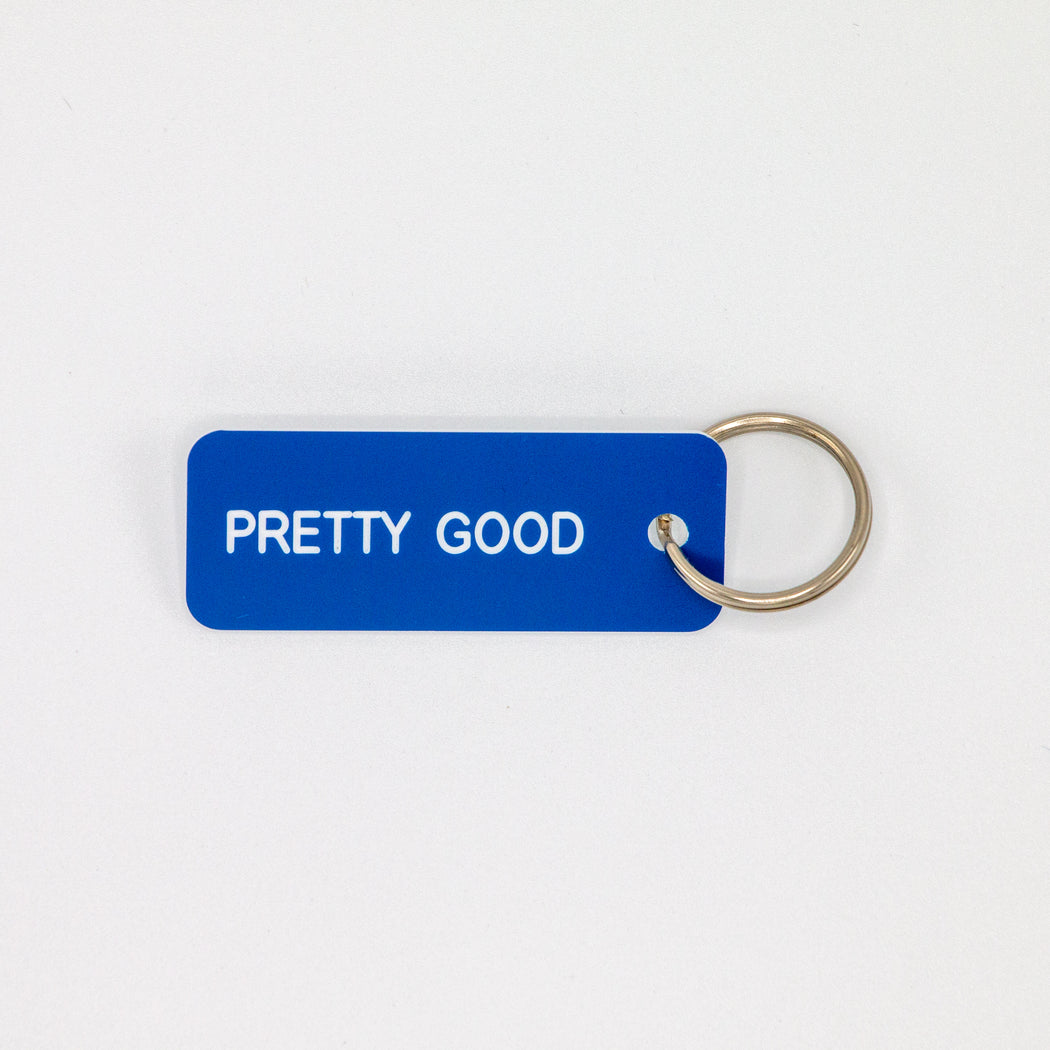 Blue rectangular  key tag reading "PRETTY GOOD" in white  print