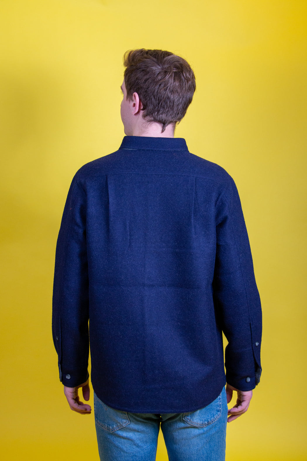 Back view of model wearing dark blue utilitarian CPO over shirt