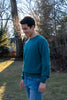 Male model wearing blue long sleeve crew neck sweater with jeans