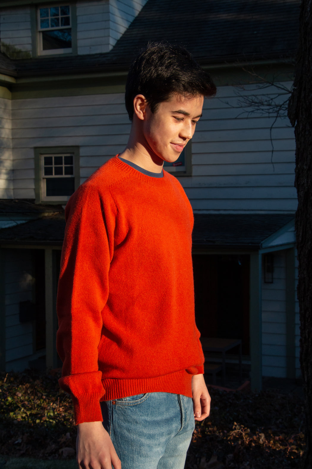 Male model wearing red long sleeve crew neck sweater with jeans 