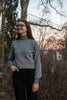 Female model wearing grey long sleeve turtleneck sweater