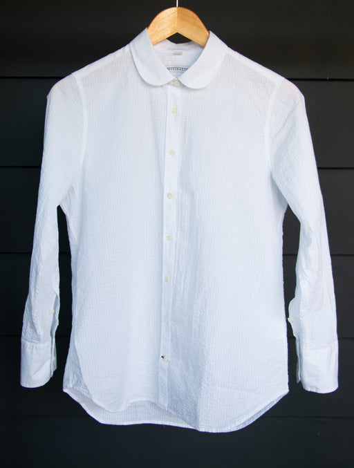 White crinkle cotton button down shirt with Peter Pan collar on hanger
