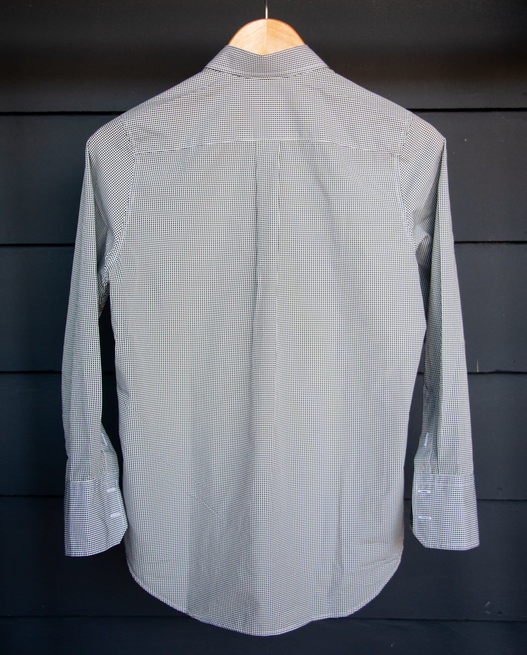 Semifinalist's black mini dot print on silky white poplin with a Peter Pan collar on wooden hanger- back view