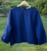 Dark blue popover shirt with grosgrain ribbon tie back closure and striped crinkle on hanger