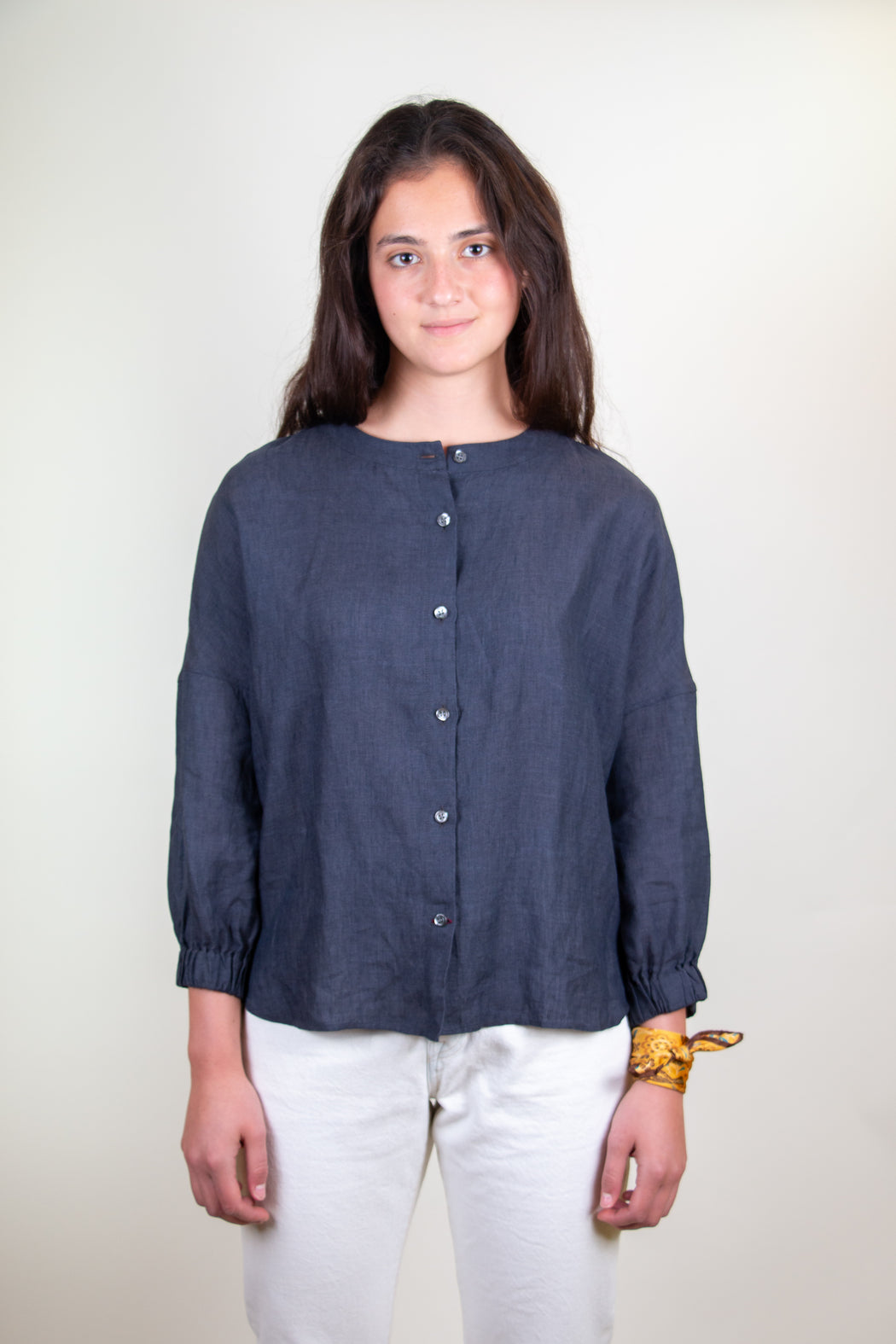 Model wearing blue grey long sleeve shirt with button front