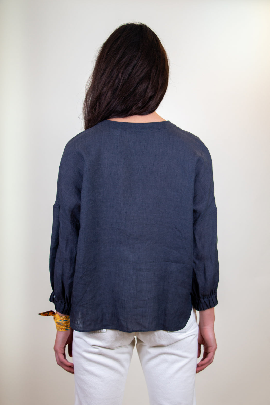 Back view:  Model wearing blue grey long sleeve shirt
