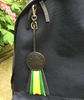 Black Leather Award Ribbon Charm with Green and Yellow leather details hanging off the side of a bag