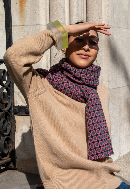 Green and pink geometric cashmere scarf wrapped around model's neck