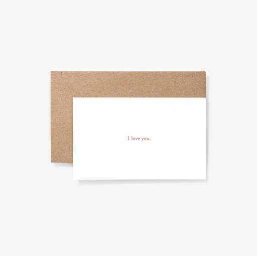 White note card reading "I love you." in front of tan envelope
