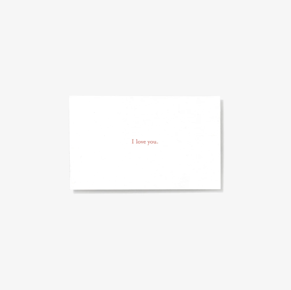 White note card reading "I love you."