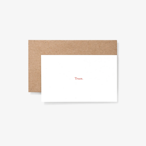 White note card reading "Truce." in front of tan envelope